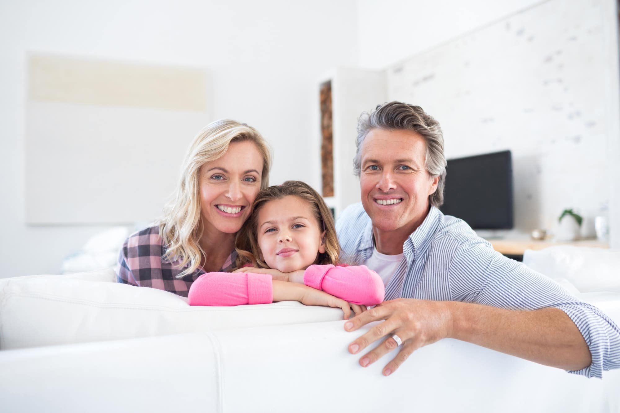 Smiling family relaxing on sofa in living room